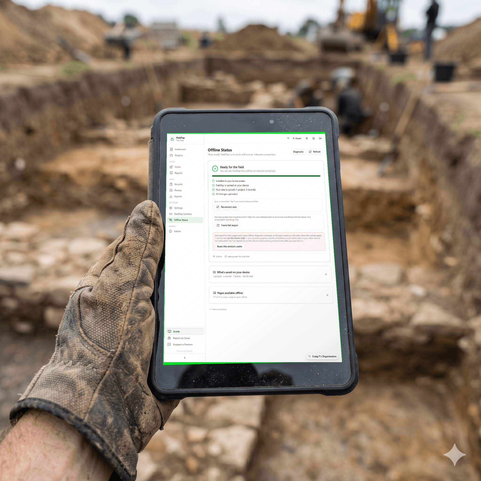 Field worker holding a tablet running FieldTap on an excavation site